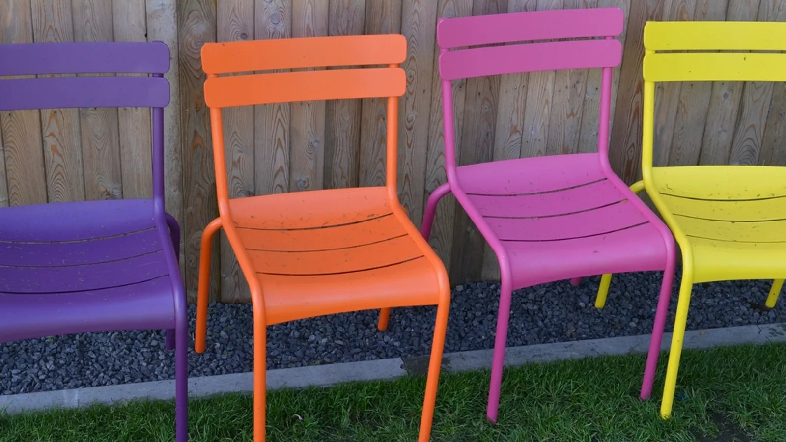 A row of brightly painted garden chairs