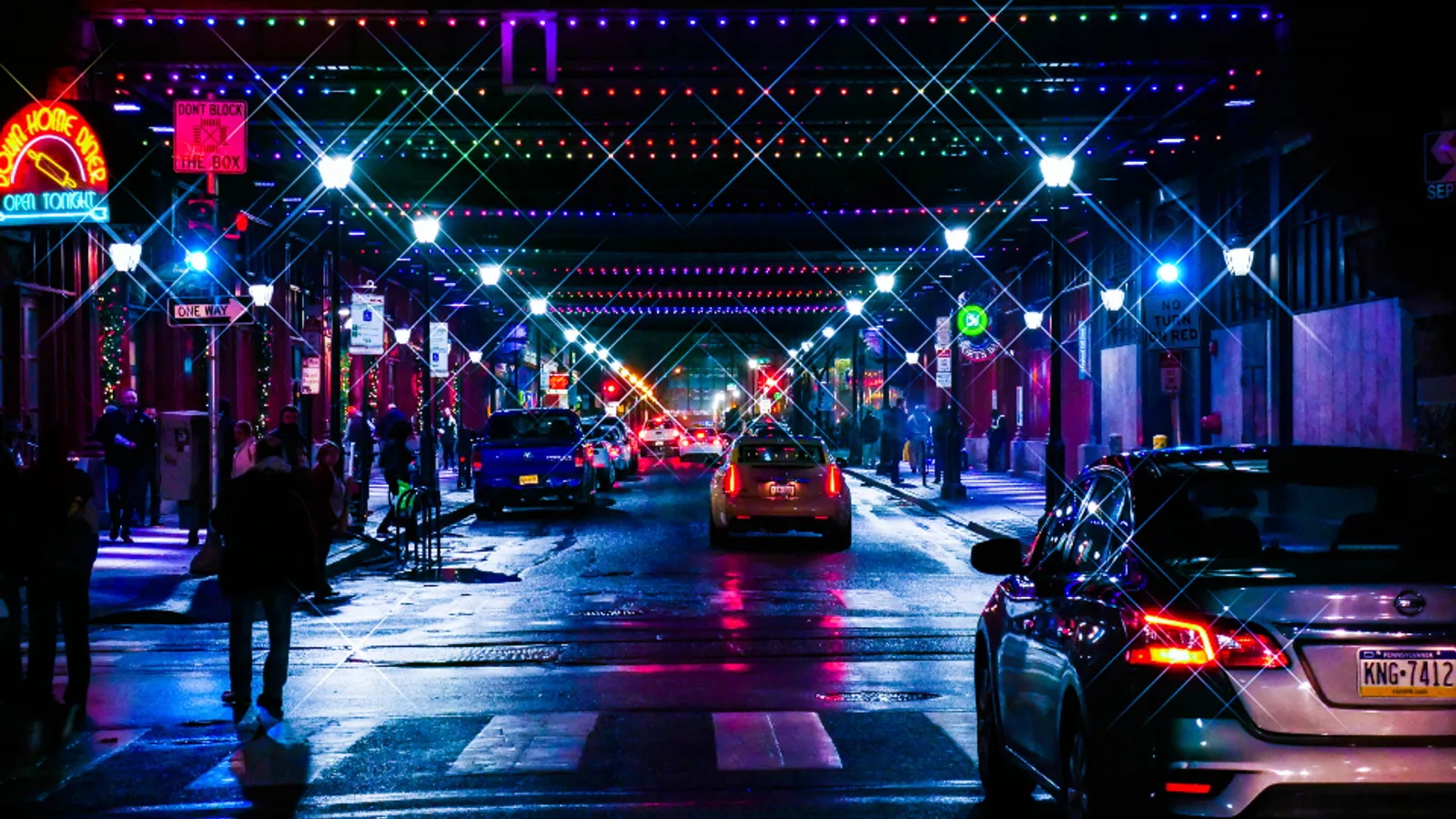 A city street at night lit by neon signs